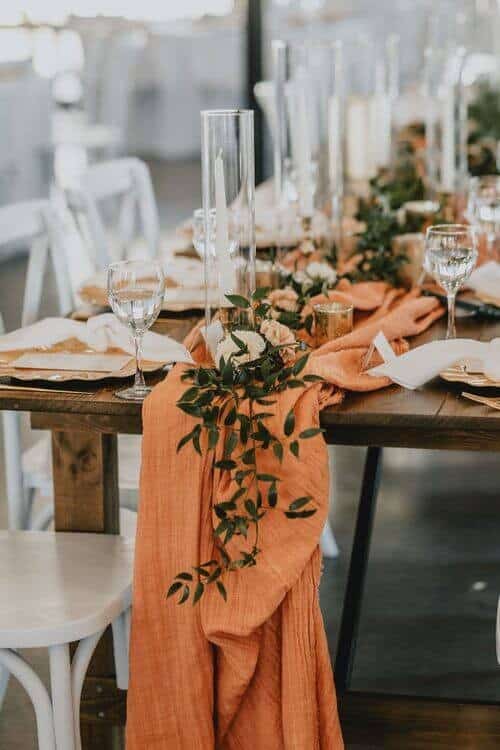 Orange table runners with greenery