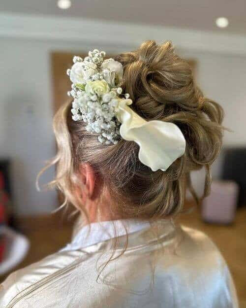 21 Curly Top Knot with Fresh Flower Adornment