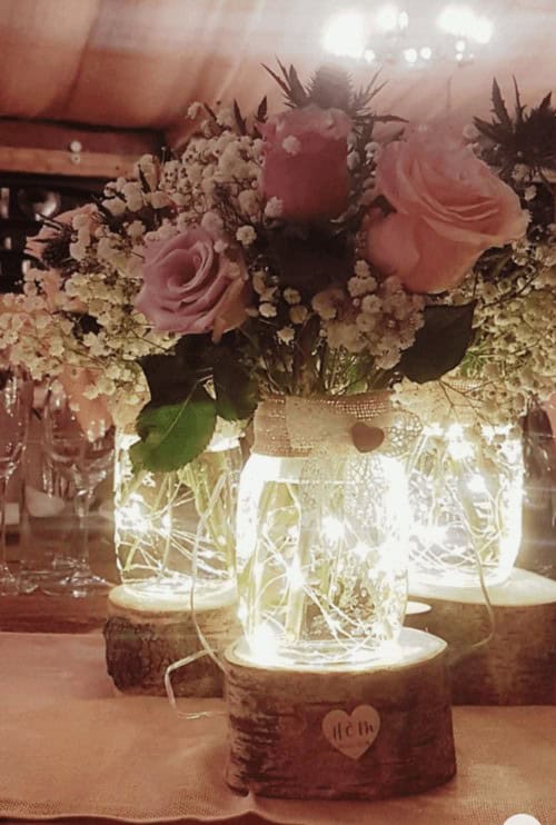 Wooden stumps and fairy light jars