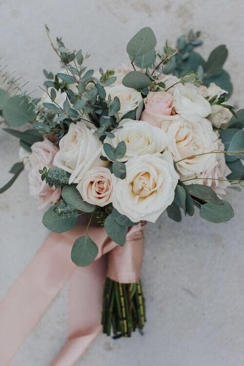 Greenery and roses wrapped in dusty pink ribbons