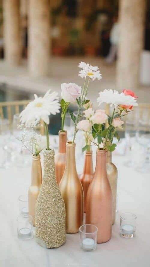 Colored wine bottle centerpieces filled with flowers