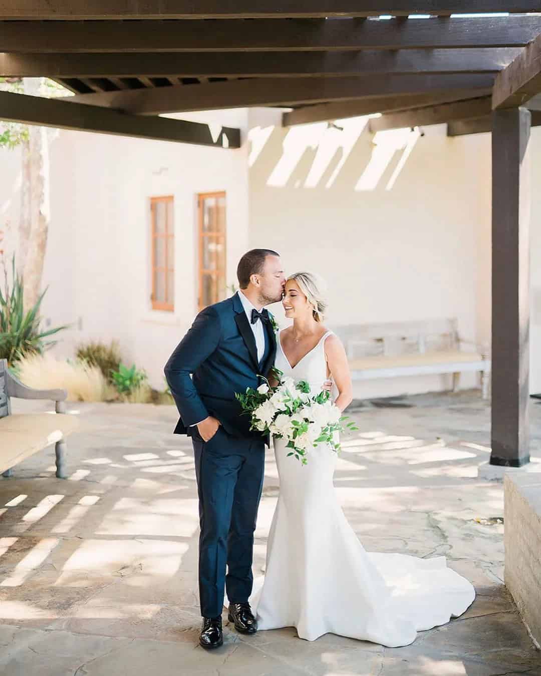 The Groom Kisses Bride’s Forehead Tenderly