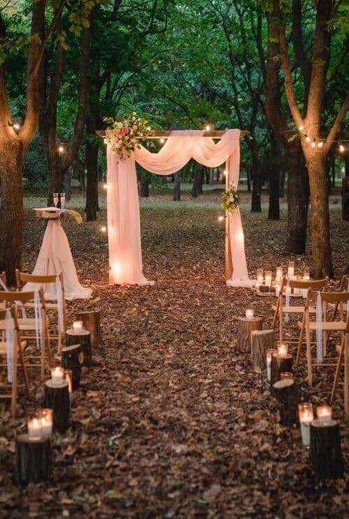 Draped fabric arches and wooden log candle holders