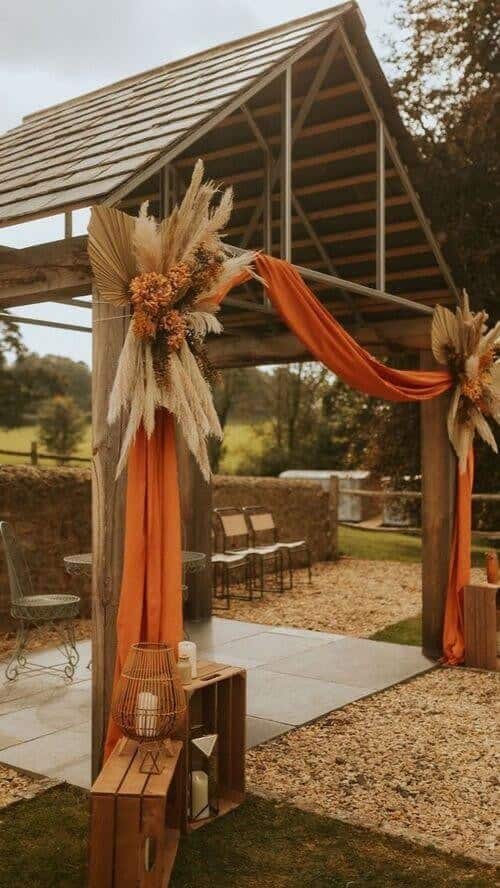 Pampas grass and orange fabric drapes