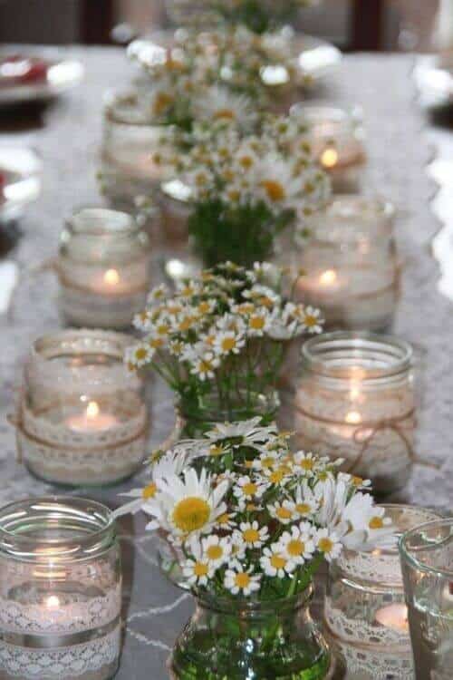 Mini jars filled with candles and daisies