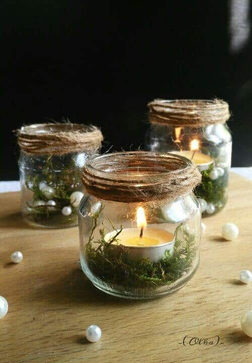 Glass jars filled with moss and tealights table decor