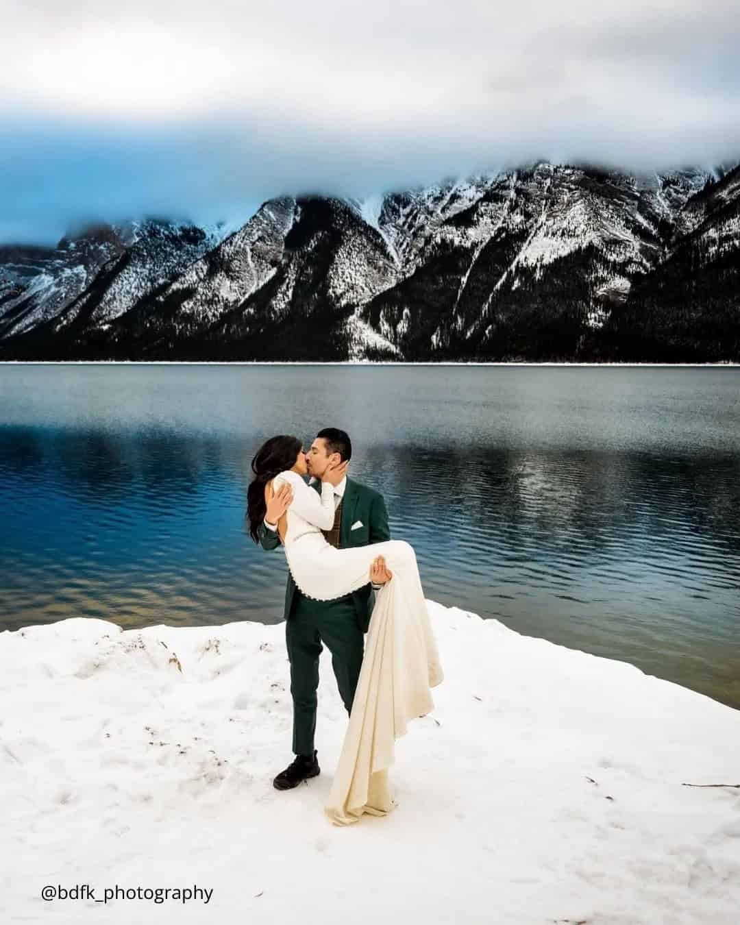 Groom Holds Bride In His Arms And Kisses