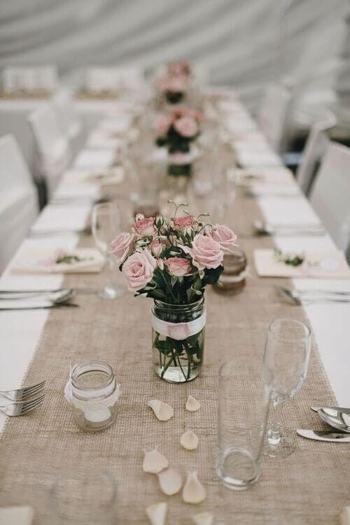 Burlap table runners with pale pink rose centerpieces