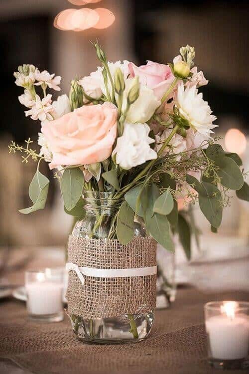 Mason jars filled with roses and greenery