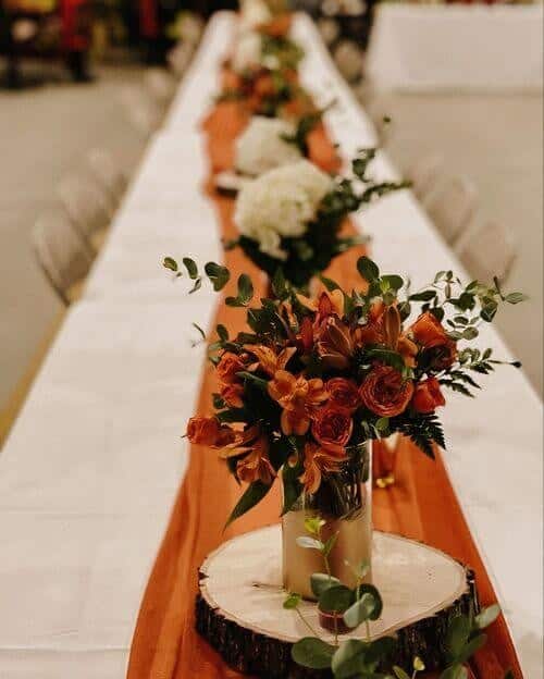 Burnt orange table runners and peach roses