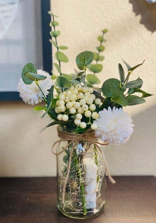 White and green bouquets in fairy light jars