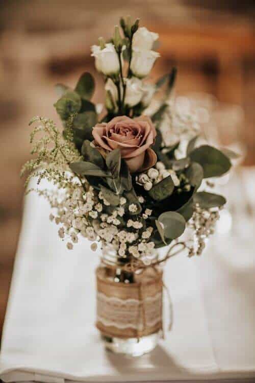 Roses and baby’s breath mason jars lined with lace and burlap