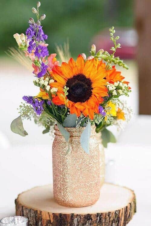 Glitter-painted mason jars filled with bright bouquets